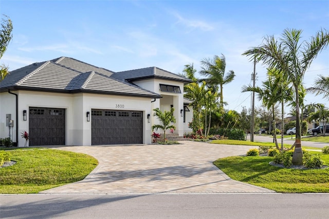 view of front of home with a garage and a front lawn