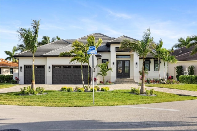 view of front of house featuring a garage, a front yard, and french doors