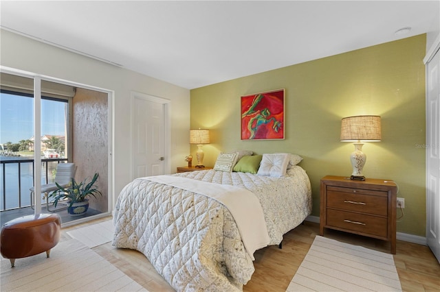 bedroom with access to exterior and light wood-type flooring