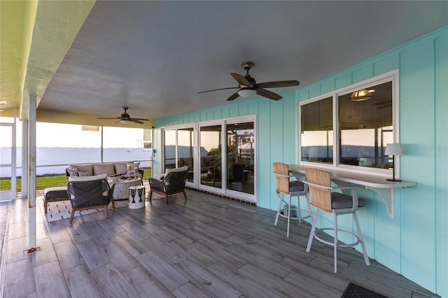 wooden terrace with an outdoor hangout area and ceiling fan