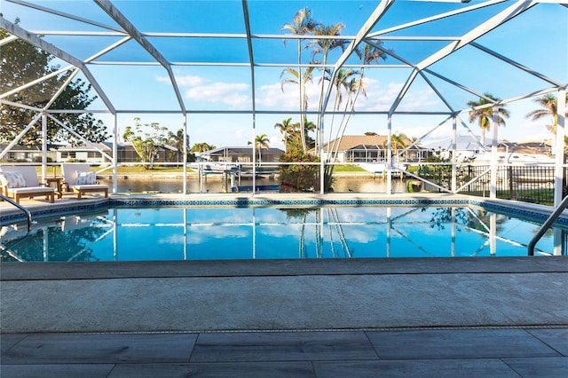 view of swimming pool with a lanai and a water view