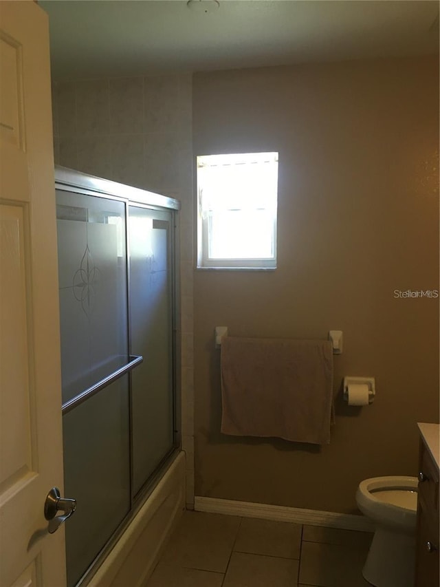 full bathroom featuring tile patterned flooring, vanity, bath / shower combo with glass door, and toilet