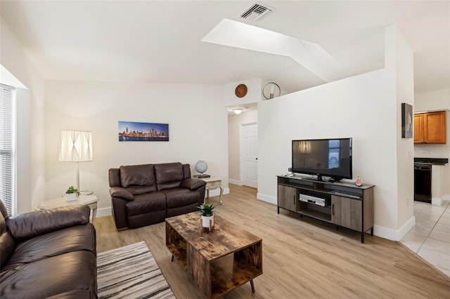 living room featuring a skylight and light hardwood / wood-style floors