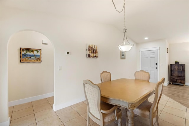 dining area featuring vaulted ceiling and light tile patterned floors