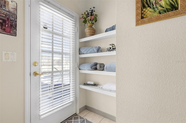 doorway to outside with light tile patterned floors