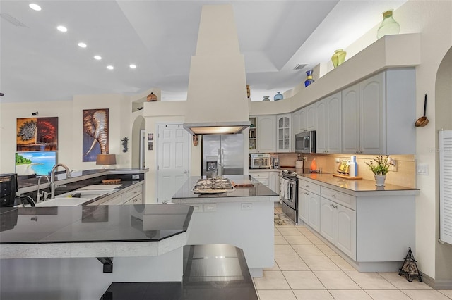 kitchen with stainless steel appliances, kitchen peninsula, sink, and light tile patterned floors