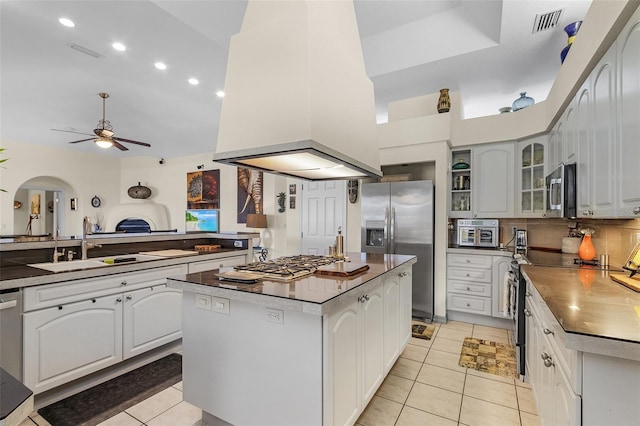 kitchen with sink, white cabinetry, light tile patterned floors, appliances with stainless steel finishes, and a kitchen island