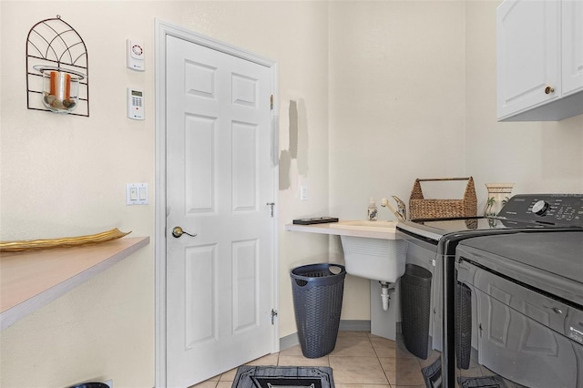 laundry room featuring cabinets, washer and dryer, and light tile patterned floors