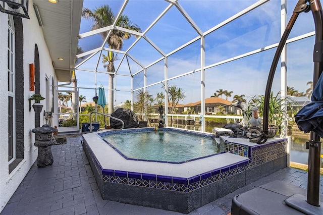 view of pool with pool water feature, a patio area, and glass enclosure