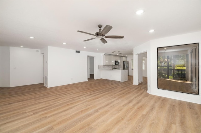 unfurnished living room featuring ceiling fan and light hardwood / wood-style floors