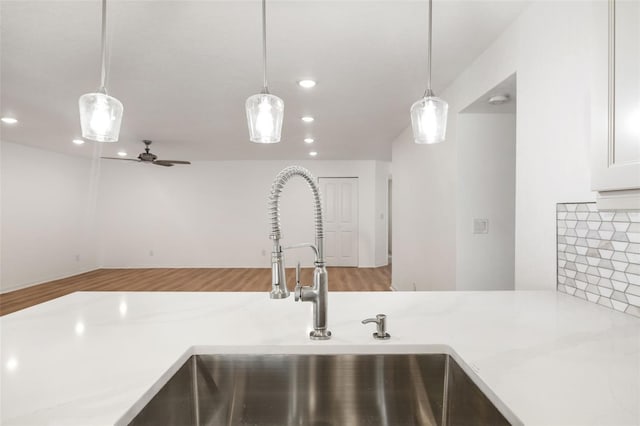 kitchen with pendant lighting, light stone countertops, and backsplash