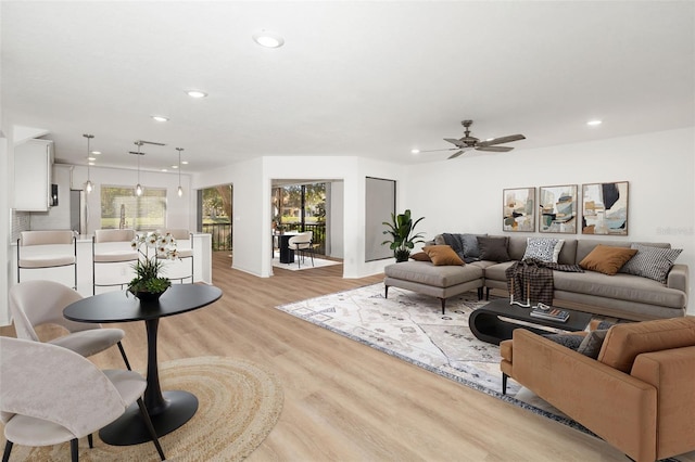 living room with ceiling fan, a healthy amount of sunlight, and light wood-type flooring