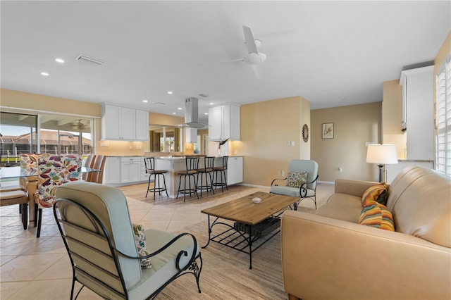 living area with light tile patterned floors, ceiling fan, recessed lighting, visible vents, and baseboards