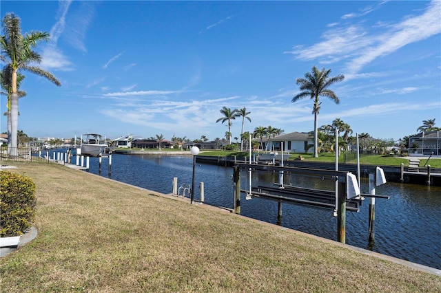 dock area with a yard, a water view, and boat lift