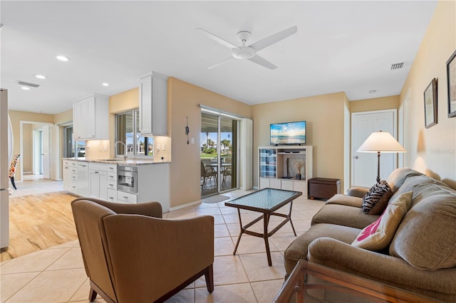 living room with light tile patterned floors, visible vents, a ceiling fan, and recessed lighting