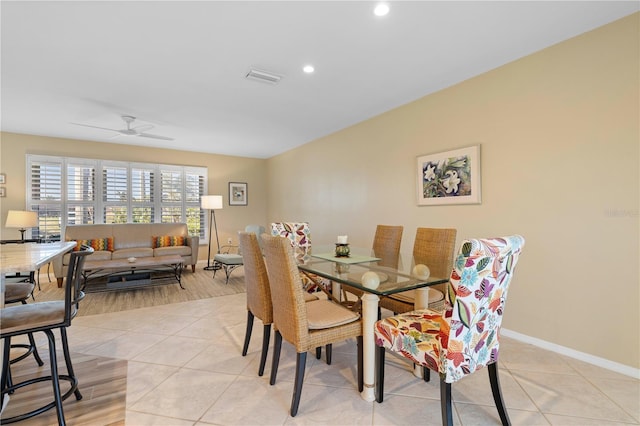 dining area with light tile patterned floors, a ceiling fan, visible vents, and baseboards