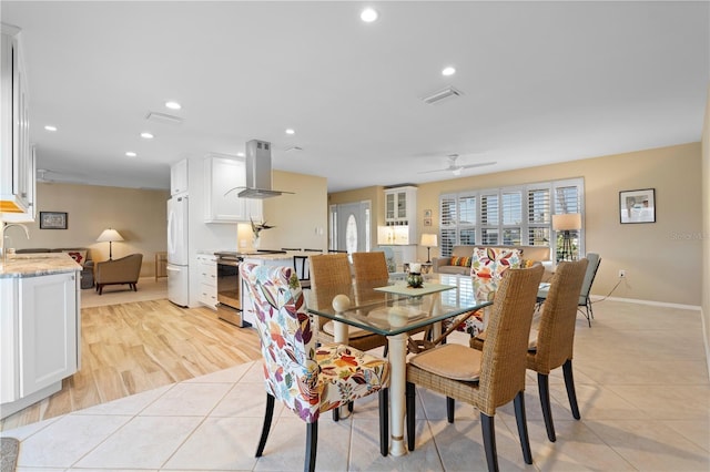 tiled dining space featuring ceiling fan and sink