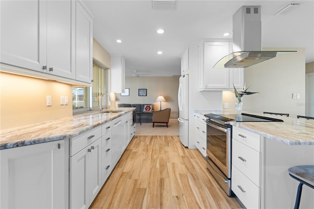 kitchen with sink, appliances with stainless steel finishes, island exhaust hood, light stone countertops, and white cabinets