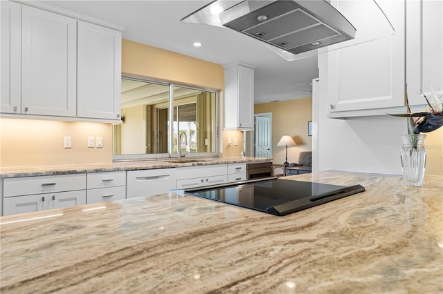 kitchen featuring white cabinetry, sink, and wall chimney range hood