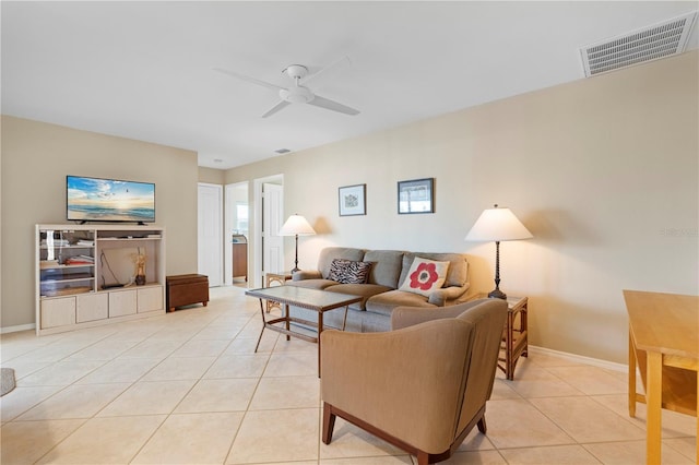 living room featuring a ceiling fan, visible vents, baseboards, and light tile patterned floors