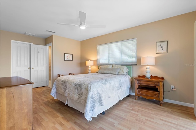 bedroom featuring light wood-type flooring, baseboards, visible vents, and a ceiling fan