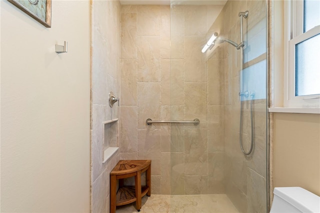 bathroom featuring toilet and tiled shower