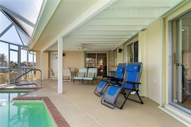 view of patio featuring glass enclosure, an outdoor pool, and a ceiling fan