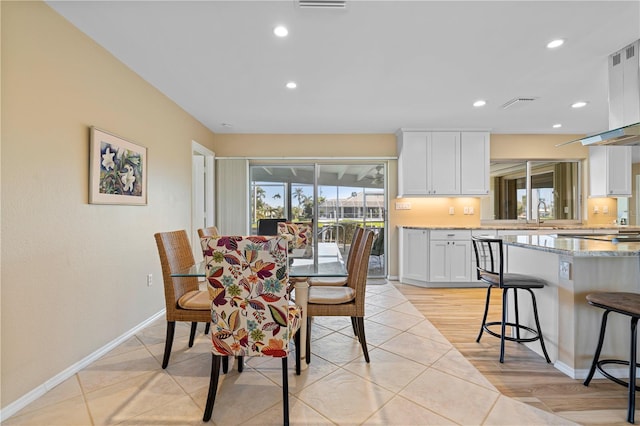 dining space with baseboards, light wood-type flooring, visible vents, and recessed lighting