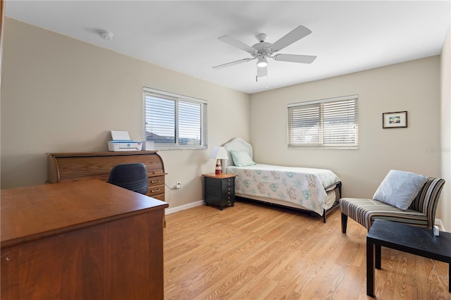 bedroom featuring baseboards, ceiling fan, and light wood finished floors