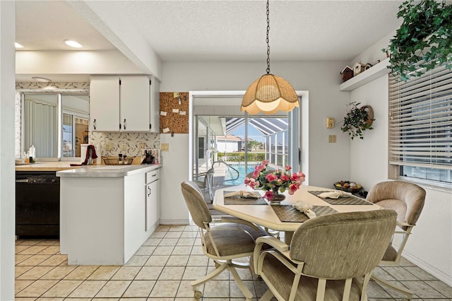 tiled dining room featuring sink and a textured ceiling