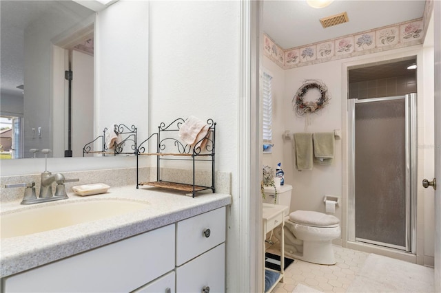 bathroom with vanity, a shower with shower door, tile patterned floors, and toilet