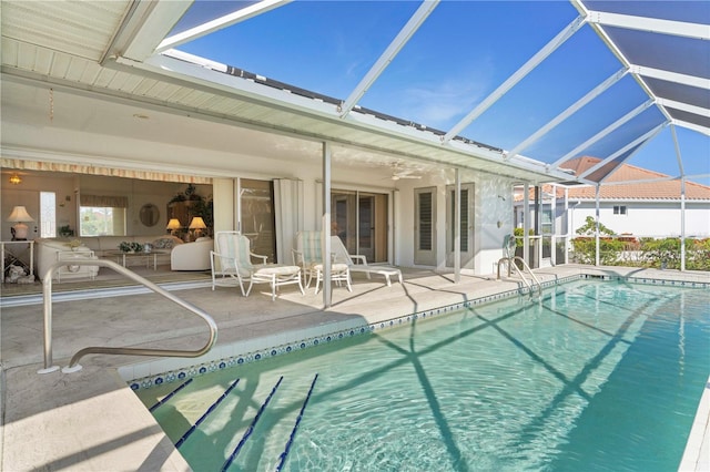 view of pool with glass enclosure and a patio area