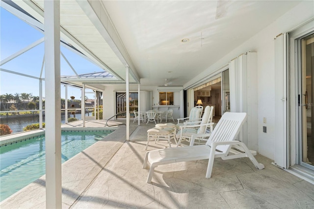 exterior space featuring a lanai, a water view, ceiling fan, and a patio area