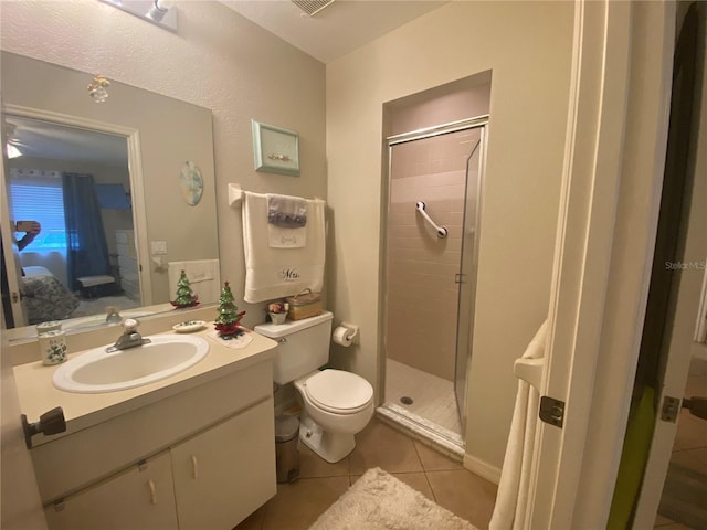 bathroom with vanity, toilet, a shower with shower door, and tile patterned flooring