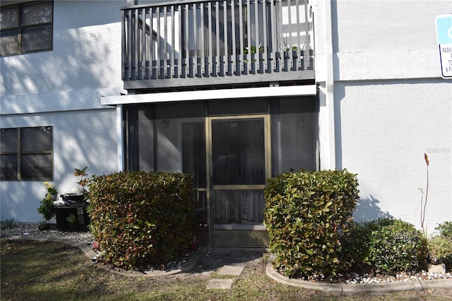 view of exterior entry with a balcony