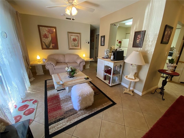 living room with light tile patterned floors, ceiling fan, visible vents, and baseboards