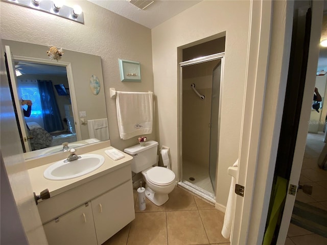 ensuite bathroom featuring connected bathroom, toilet, vanity, tile patterned floors, and a stall shower