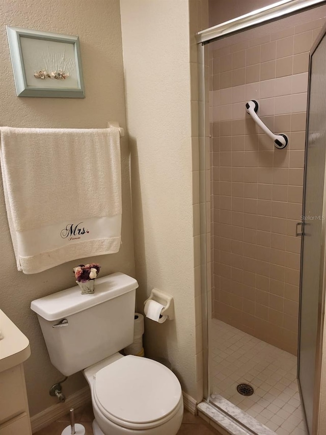 full bath featuring toilet, a stall shower, baseboards, and vanity