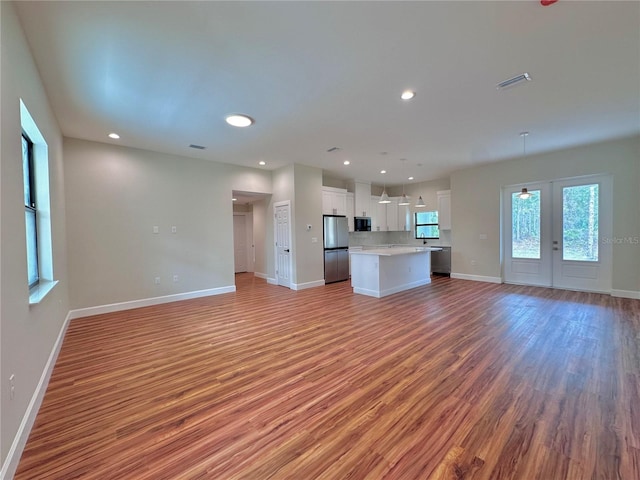 unfurnished living room featuring hardwood / wood-style flooring and french doors