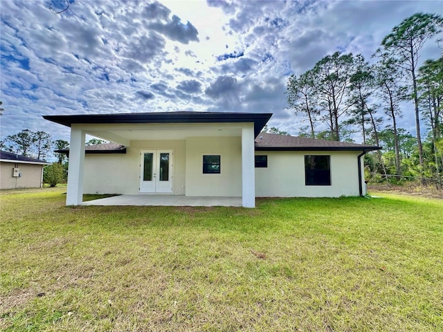 back of house with a patio area, a yard, and french doors