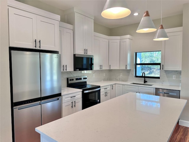 kitchen featuring white cabinetry, sink, hanging light fixtures, and appliances with stainless steel finishes