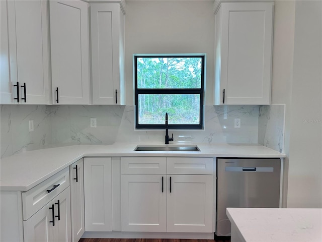 kitchen with tasteful backsplash, sink, stainless steel dishwasher, and white cabinets