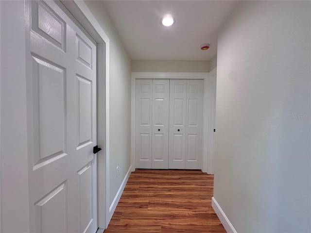 corridor with dark wood-style floors and baseboards