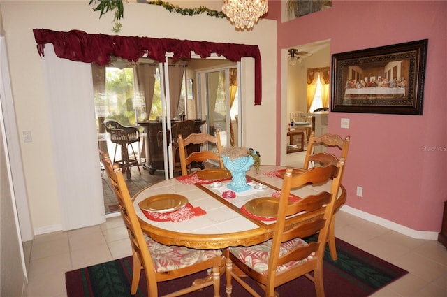 tiled dining room with a chandelier