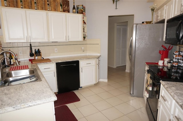 kitchen featuring sink, light tile patterned floors, black appliances, white cabinets, and decorative backsplash