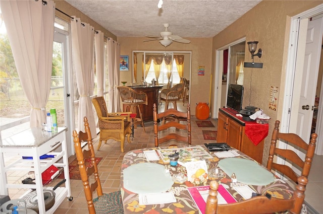 dining room featuring ceiling fan and a textured ceiling