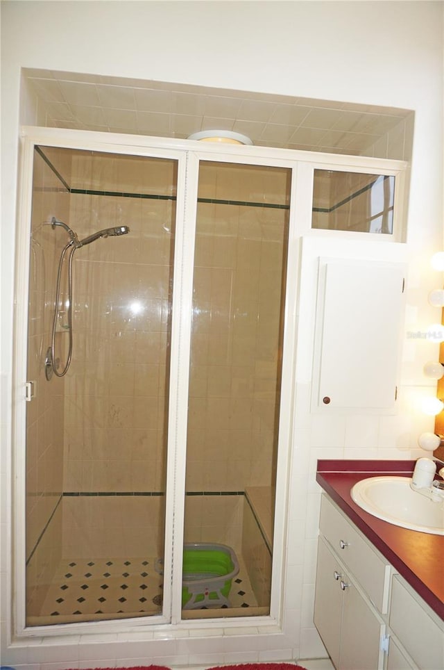 bathroom with vanity and a shower with door