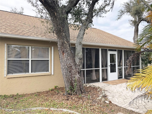 rear view of property featuring a patio area and a sunroom