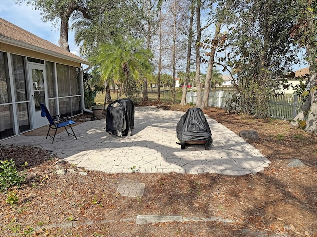 view of patio / terrace featuring area for grilling, a fire pit, and a sunroom