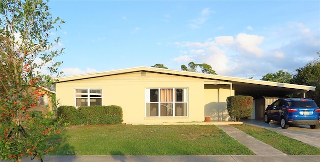 view of front facade with a carport and a front yard